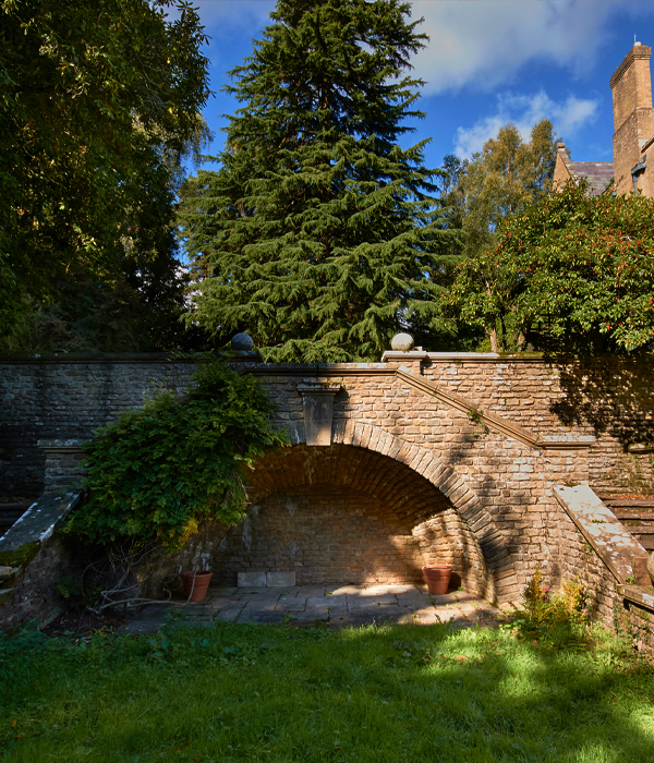 A stone archway surrounded by green trees and bushes