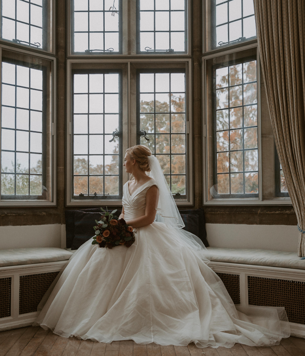 Bride sitting in a large bay window