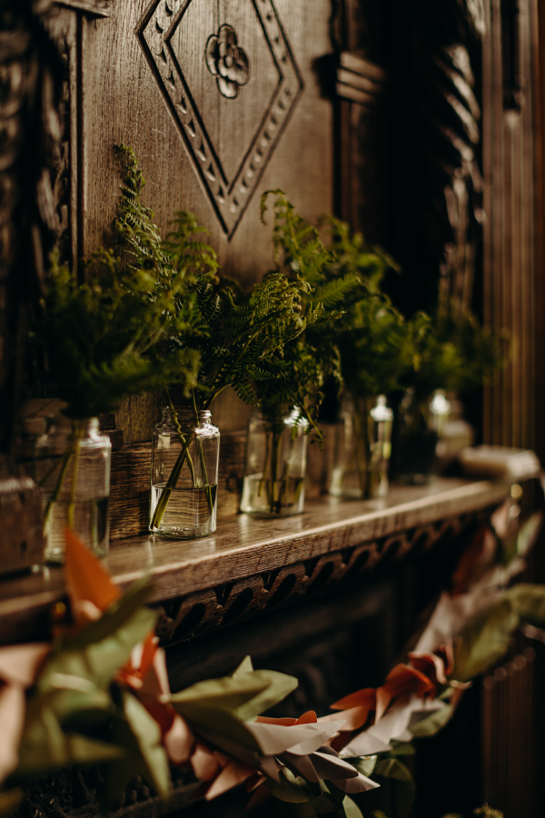 A wood panelled fireplace decorated with foliage and garlands