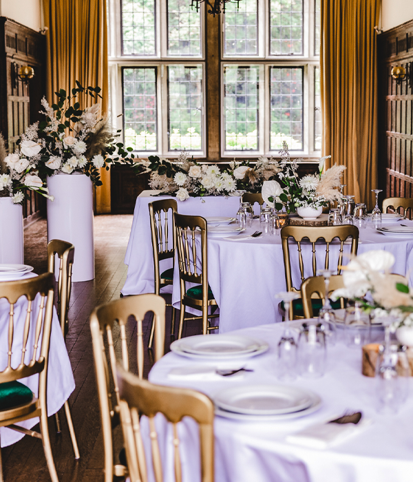 Wedding reception showing round tables with decorations and flowers.