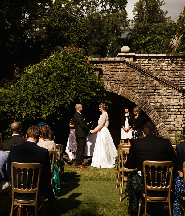 Couple getting married under a stone archway