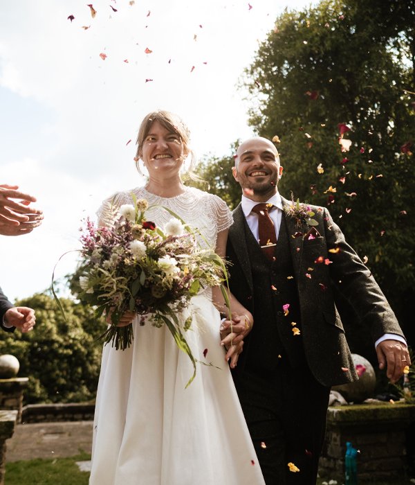 Bride and Groom walking with confetti thrown over them