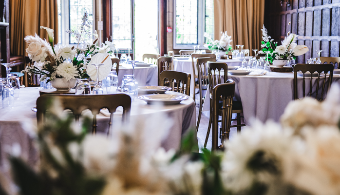 Wedding reception showing round tables with decorations and flowers.